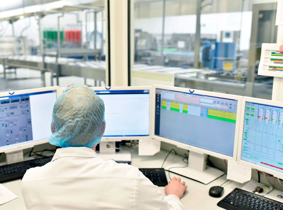 A technician oversees multiple computer screens
                  in the control room of a processing plant